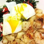 Emmas Eggs. This picture depicts two poached eggs on top of a bed of sautéed spinach and roasted peppers with an additional water of home fries accompanied on the side for an extra charge, served on a weekly