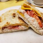 Tuna Melt on Pita. This picture the pics tuna salad with sliced tomatoes melted American cheese on a pita served on a white platter on Johnys Luncheonette