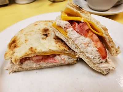 Tuna Melt on Pita. This picture the pics tuna salad with sliced tomatoes melted American cheese on a pita served on a white platter on Johnys Luncheonette